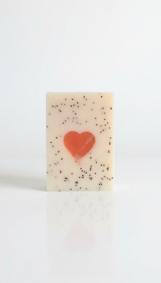 Bar of soap with a red heart and poppy seed embossing on a white background